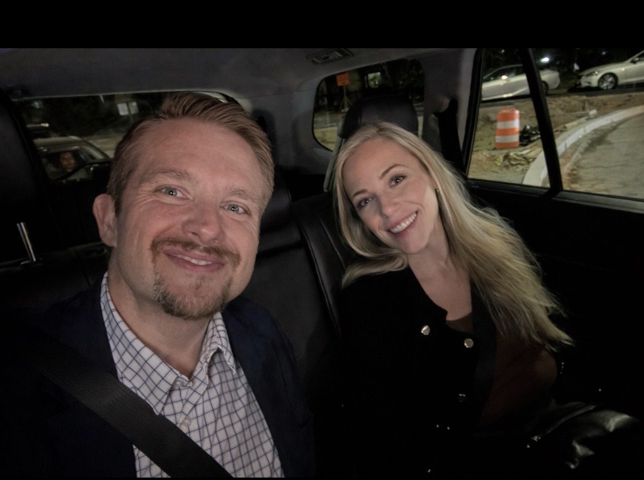 Two people in the back of a car on a night out