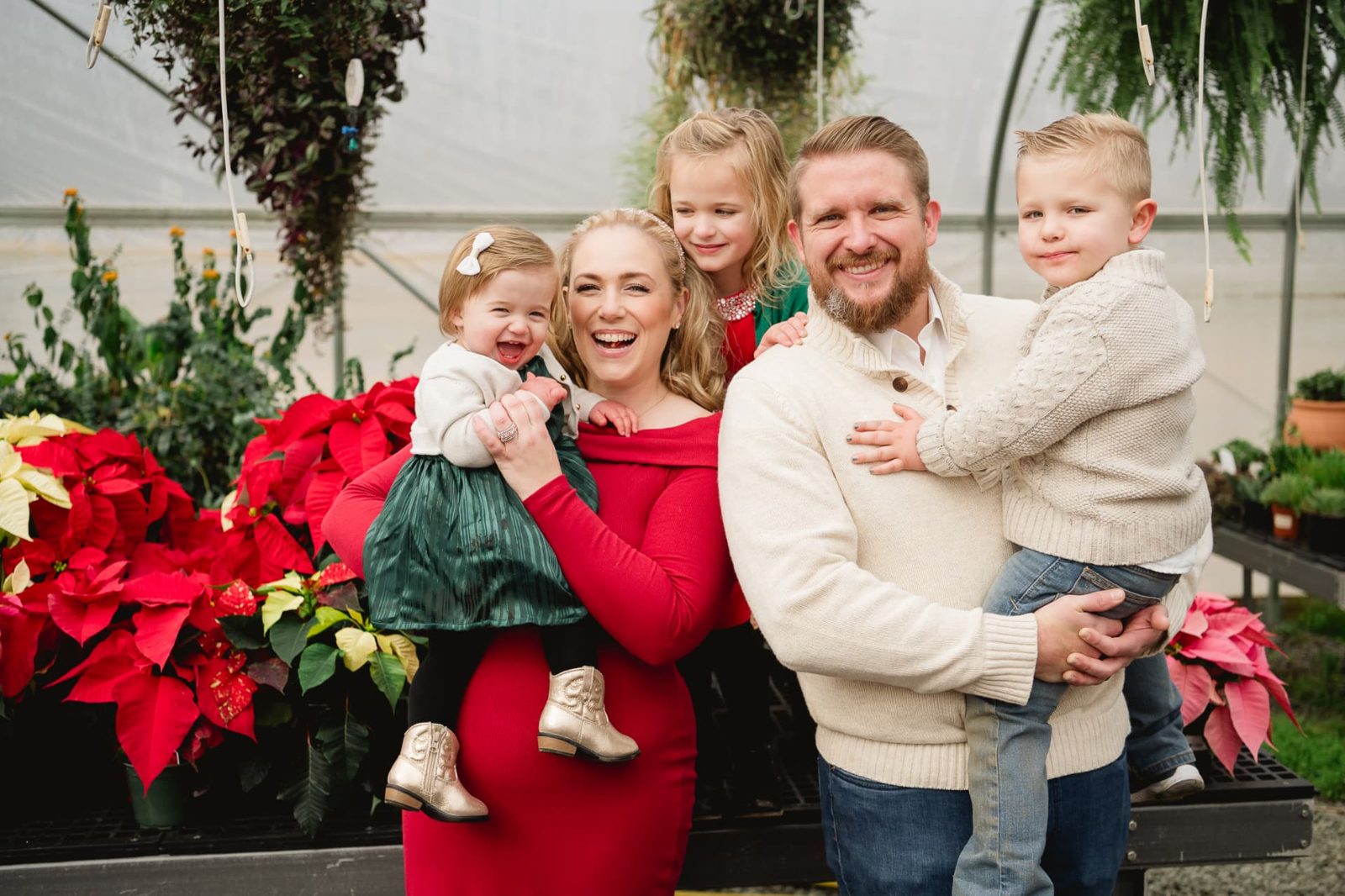 The family in a greenhouse among the poinsettias at Christmas